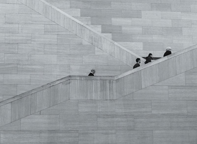 men climbing up stairs black and white